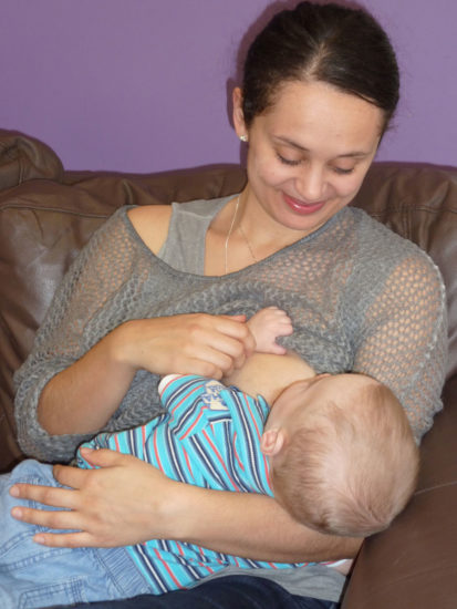 baby breastfeeds in a cradle hold