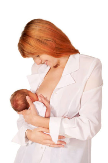 Mother holding baby to breastfeed while standing up