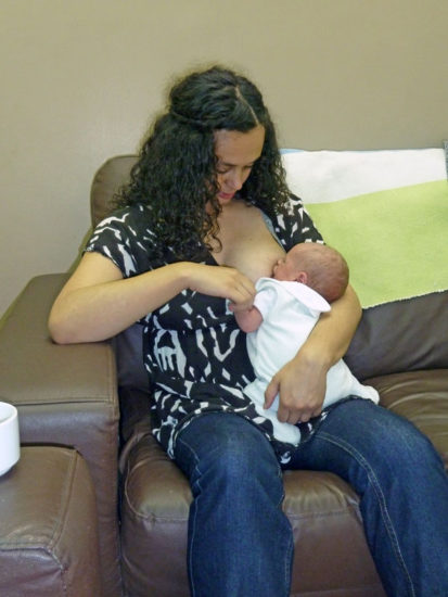 mother holding baby to breastfeed in a straddle hold