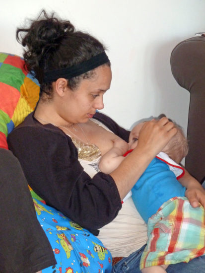 mother holding baby to breastfeed in a reclining straddle hold