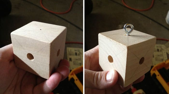 Из деревянного куба и металлического крюка делают держатель для игрушек. В кубе просверливают 4 отверстия, в которые вставляют палочки. На палочках развешивают игрушки, а крюк крепится к каркасу изделия