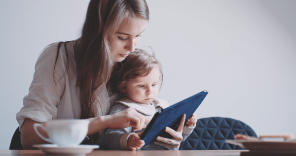 Женщина с ребёнком смотрят в планшет