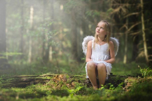 Девочка с ангельскими крыльями в лесу