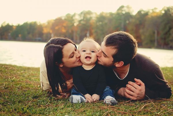 Родители целуют ребёнка