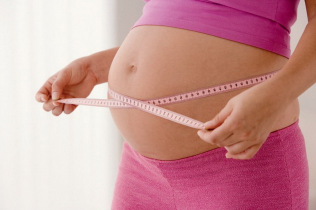 беременная измеряет живот