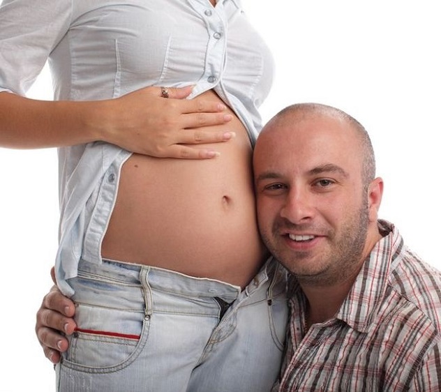 мужчина слушает как пульсирует живот при беременности